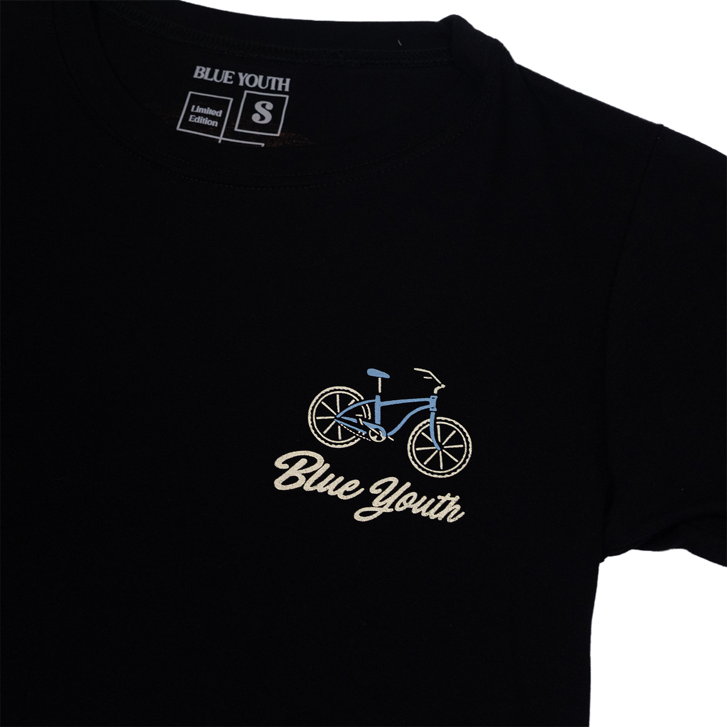 Crop top negro con ilustración nostálgica de Puerto Viejo: esqueleto en bicicleta junto al mar, con tabla de surf y ola al fondo.