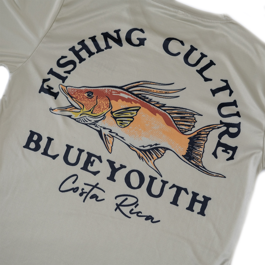 Camisa inspirada en el hogfish con detalles coloridos, colgada en un entorno natural tropical.