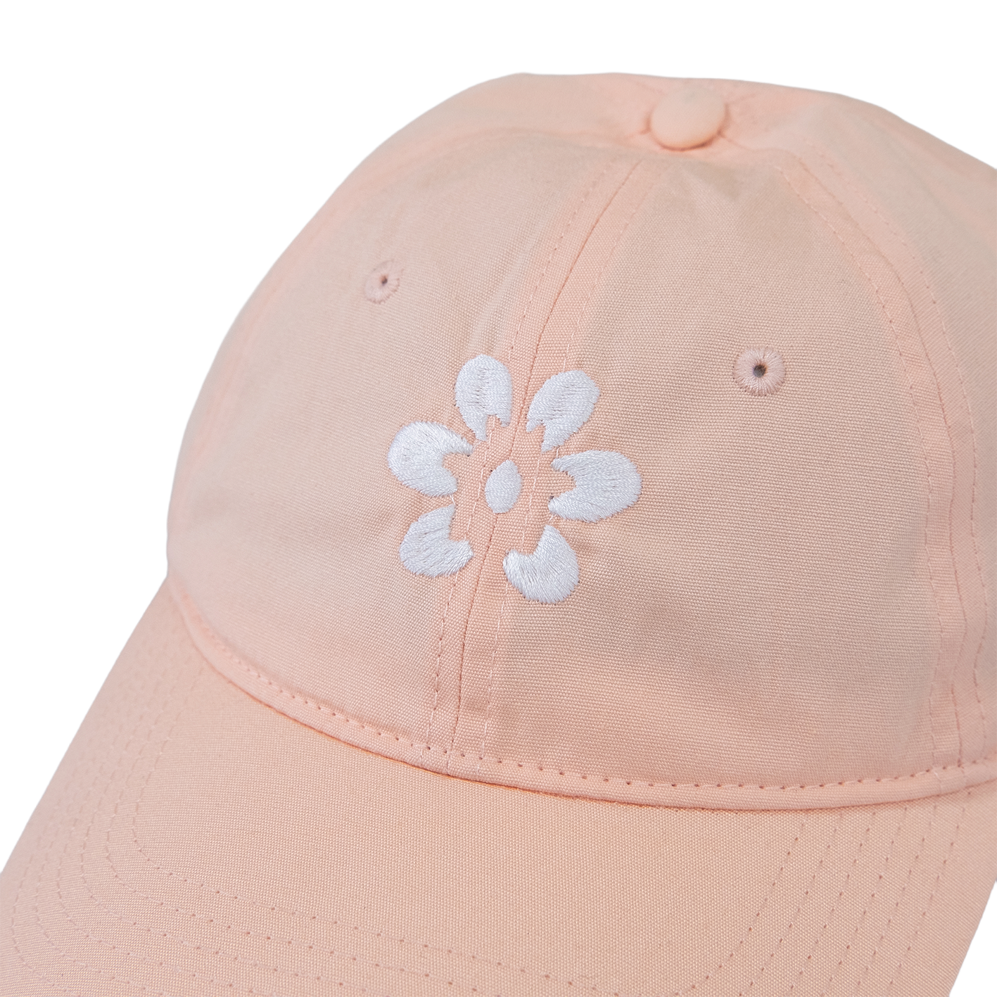 Gorra color rosa claro con flor blanca bordada al frente, diseño estilo minimalista.