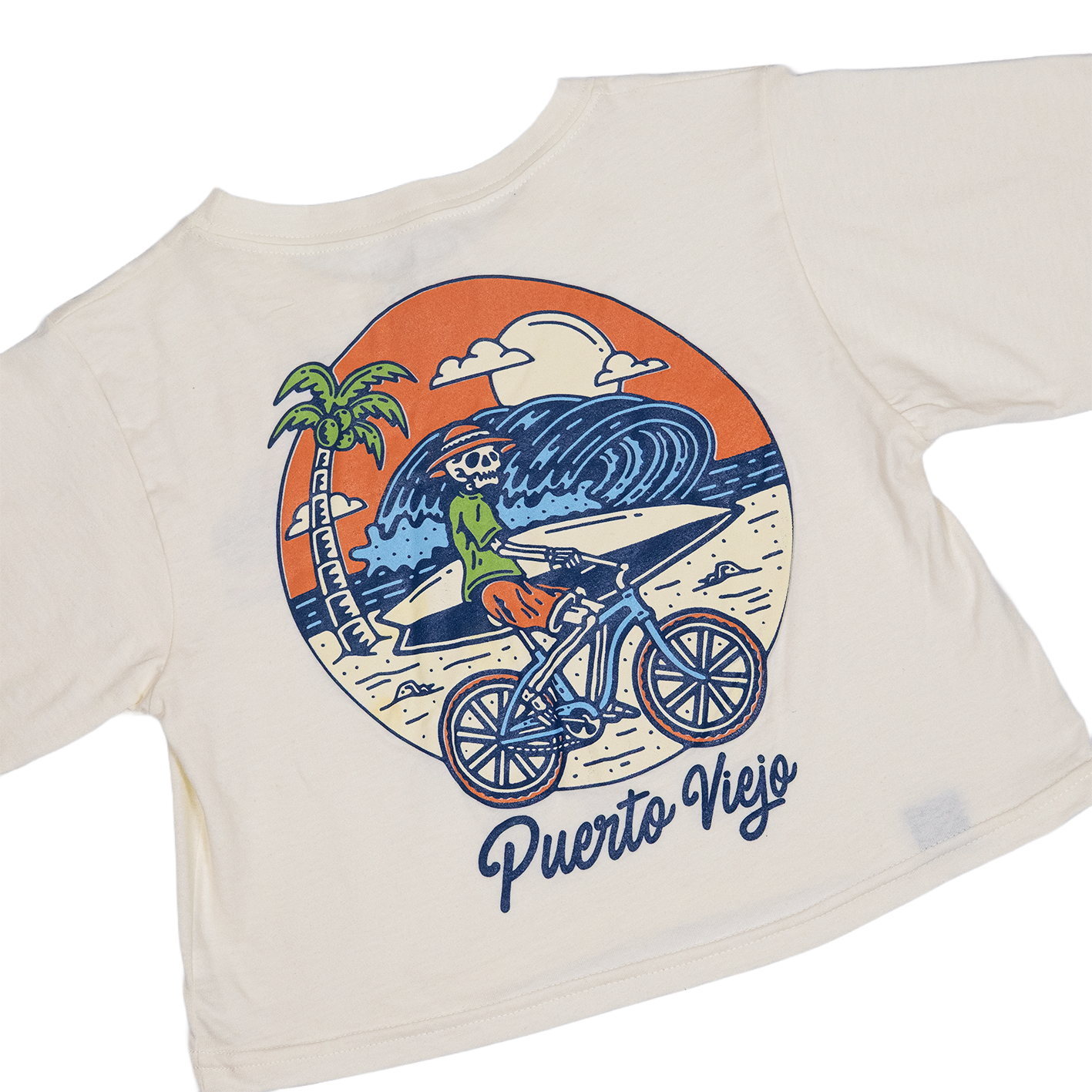 Crop top blanco
 con ilustración de esqueleto en bicicleta en la playa de Puerto Viejo, con ola gigante y palmera al fondo.

